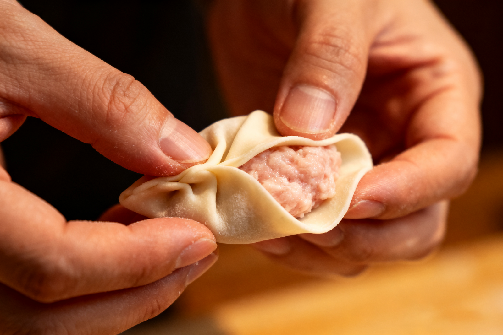 Folding dumplings by hand (jiaozi), close-up