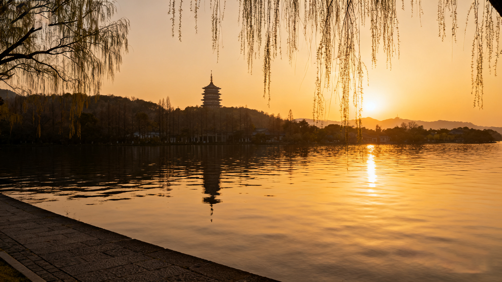 West Lake at dusk: Su Causeway and Leifeng Pagoda reflected on calm water; willow lines create a slow-walking scene